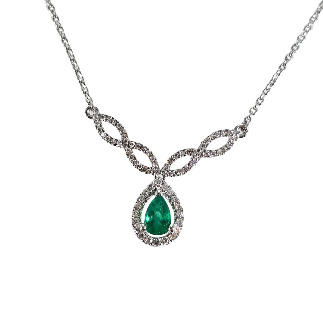 White gold station necklace with interwoven curves of round diamonds centering a pear shaped emerald.