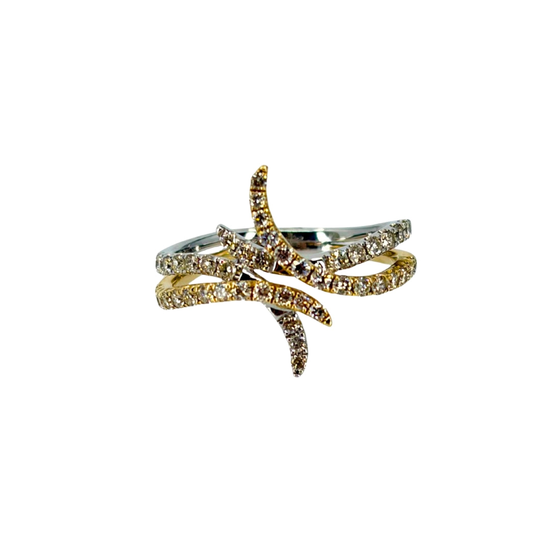 Two tone gold free form design ring with flowing bands of white and yellow gold and set with shimmering round diamonds.