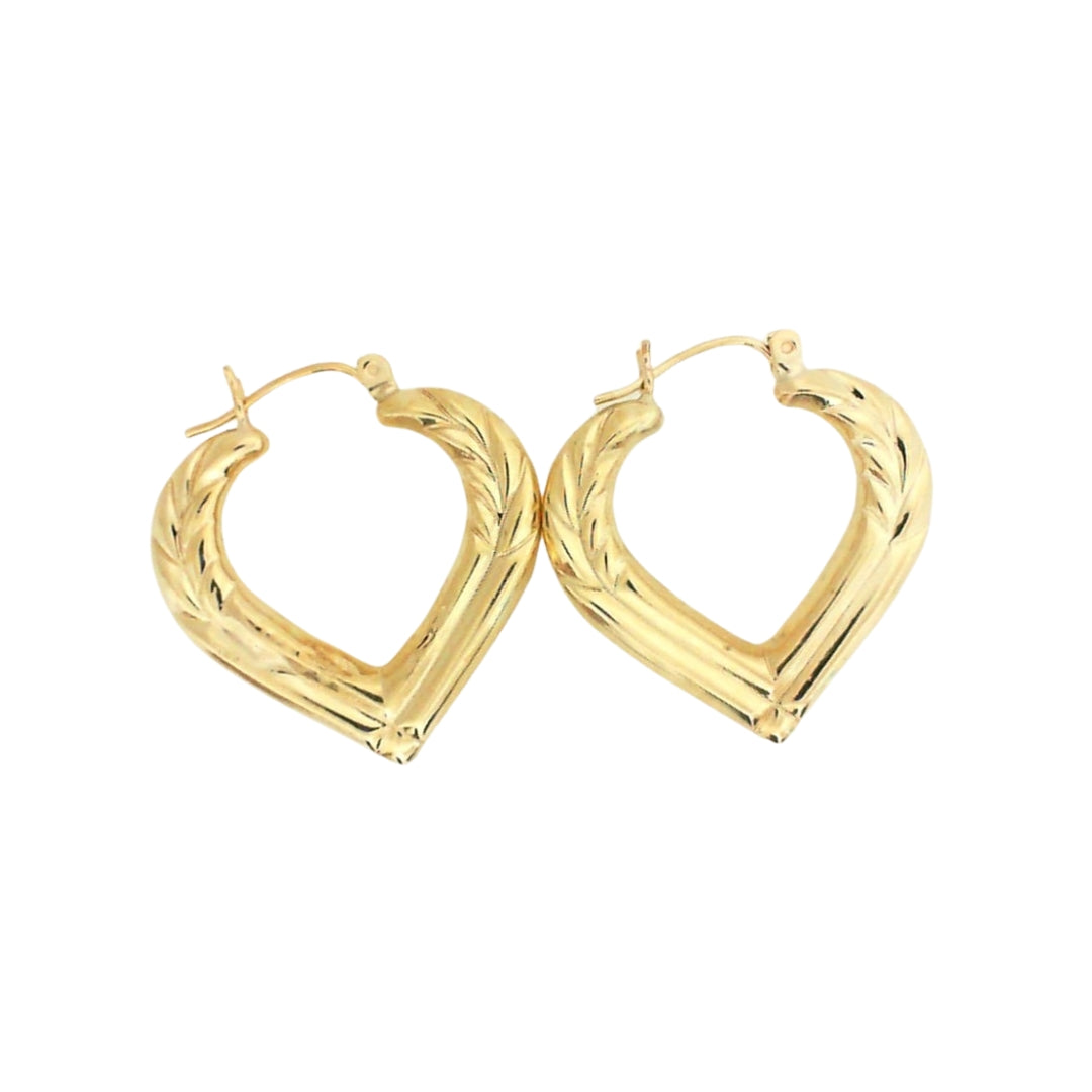Gold hoop earrings in a heart shape with engraved design.