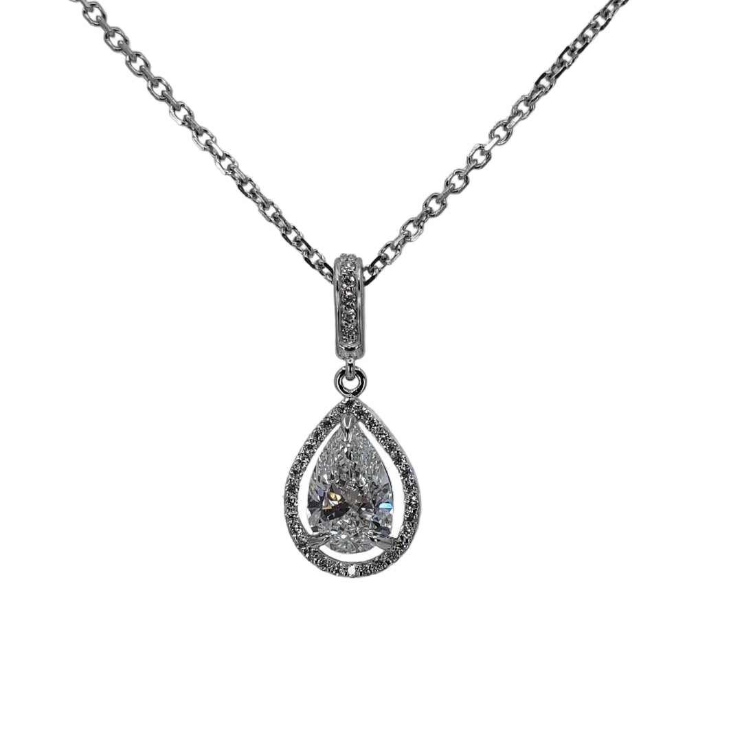 White gold halo pendant with lab diamond in the center suspended from a white gold chain in front of a white background.
