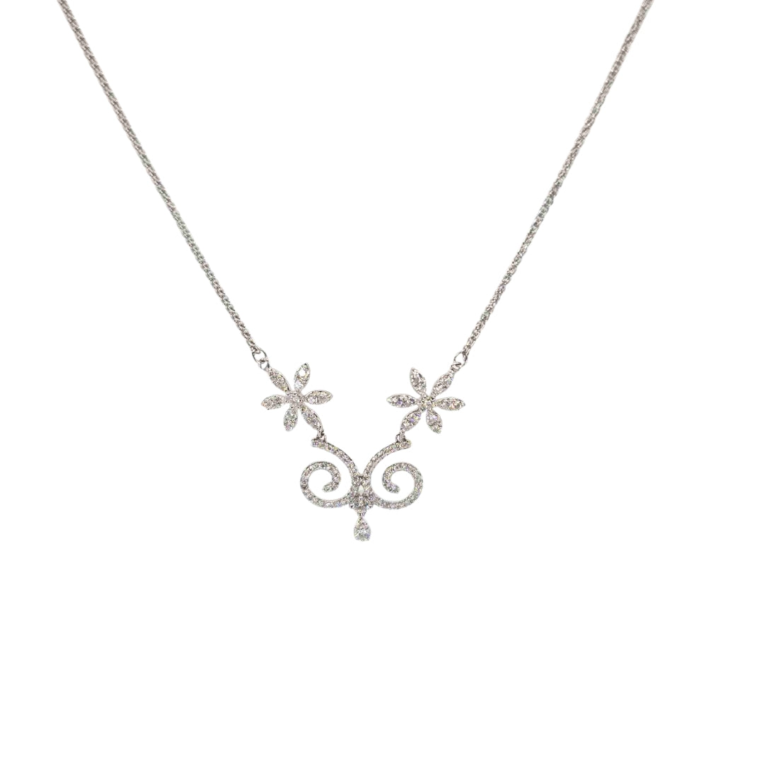 White gold necklace with a central swirling design accented with two floral patterns, all adorned with sparkling round diamonds.