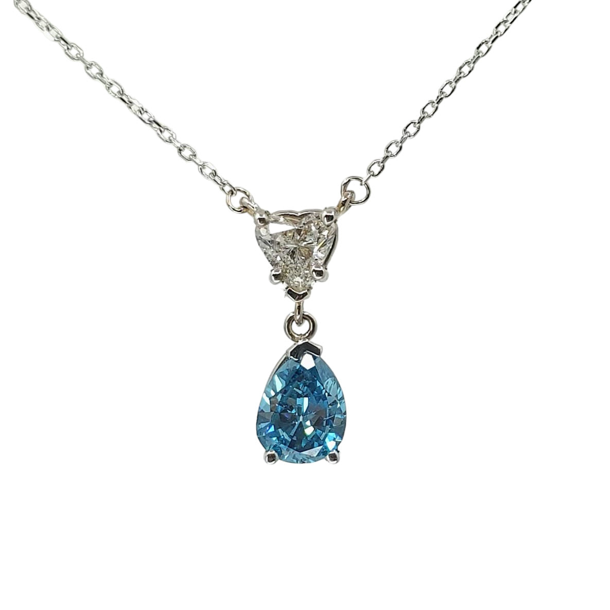 White gold station necklace with a heart shaped diamond with a blue diamond descending from it on a white background.