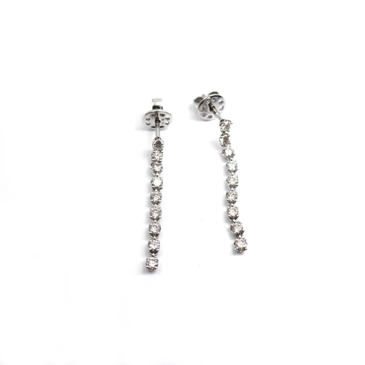 White gold earrings with descending round diamonds on a white background.
