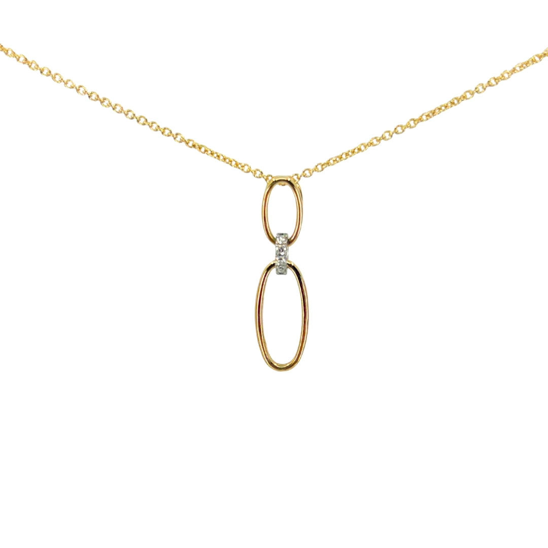 Yellow gold necklace with two descending oval pendants connected with a white gold oval bail set with round diamonds.