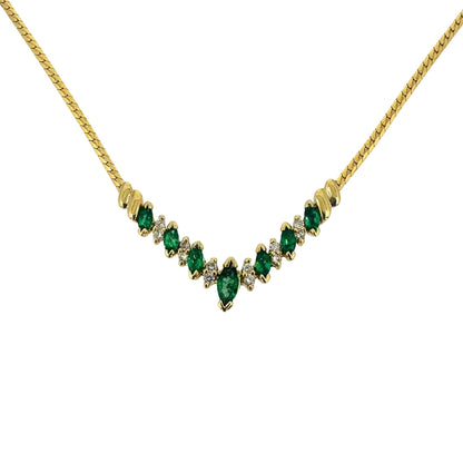 Yellow gold necklace with an alternating marquise emerald and round diamond vee station centerpiece on a yellow gold chain.