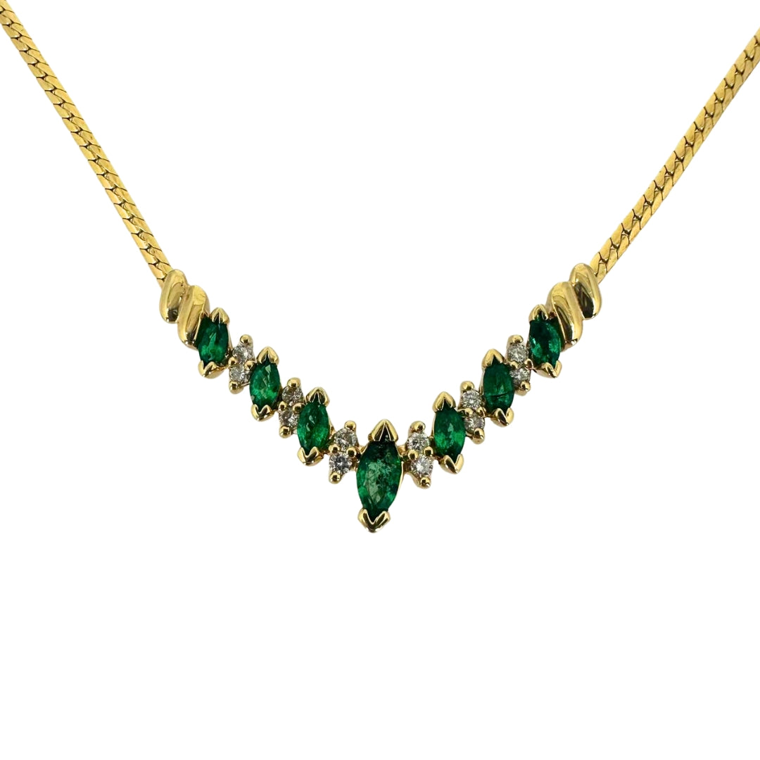 Yellow gold necklace with alternating marquise emeralds and round diamonds in a vee shape.