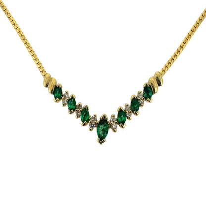 Yellow gold necklace with alternating marquise emeralds and round diamonds in a vee shape.