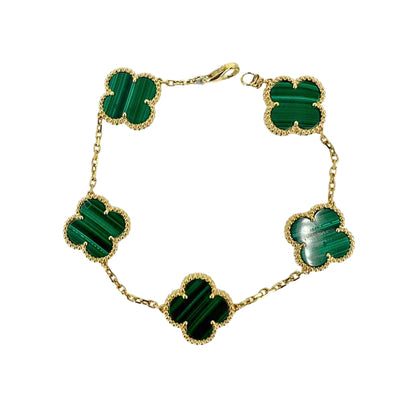Yellow gold bracelet with 5 malachite quatrefoil clovers evenly spaced along the gold chain.