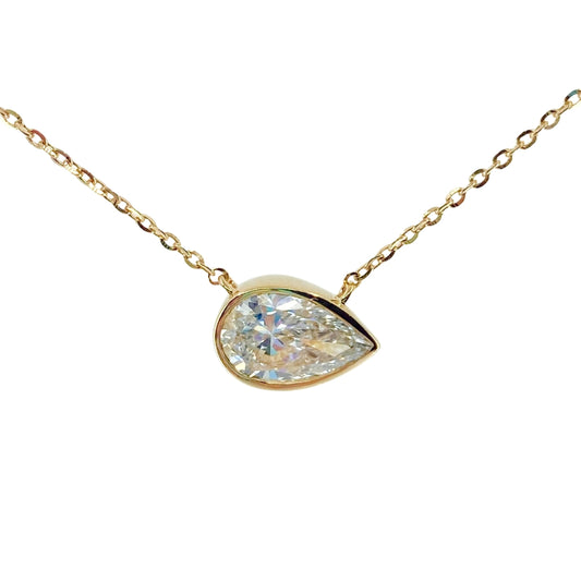 Yellow gold necklace with a bezel set pear shaped lab grown diamond shimmering from the center.