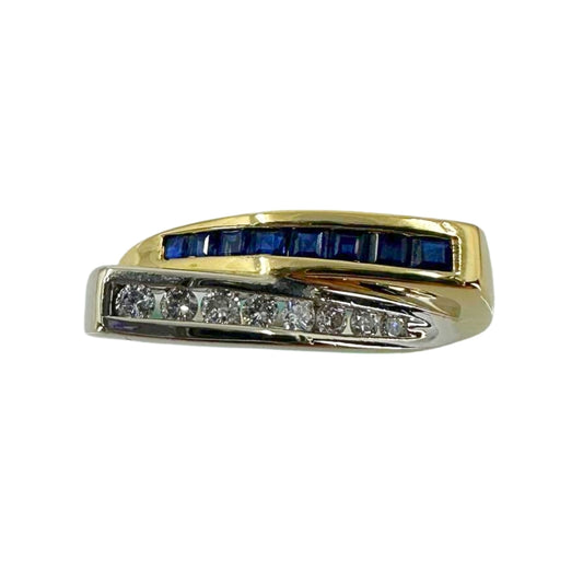 Two tone gold bypass ring with deep blue sapphires channel set in yellow gold bypassing brilliant round diamonds channel set in white gold.