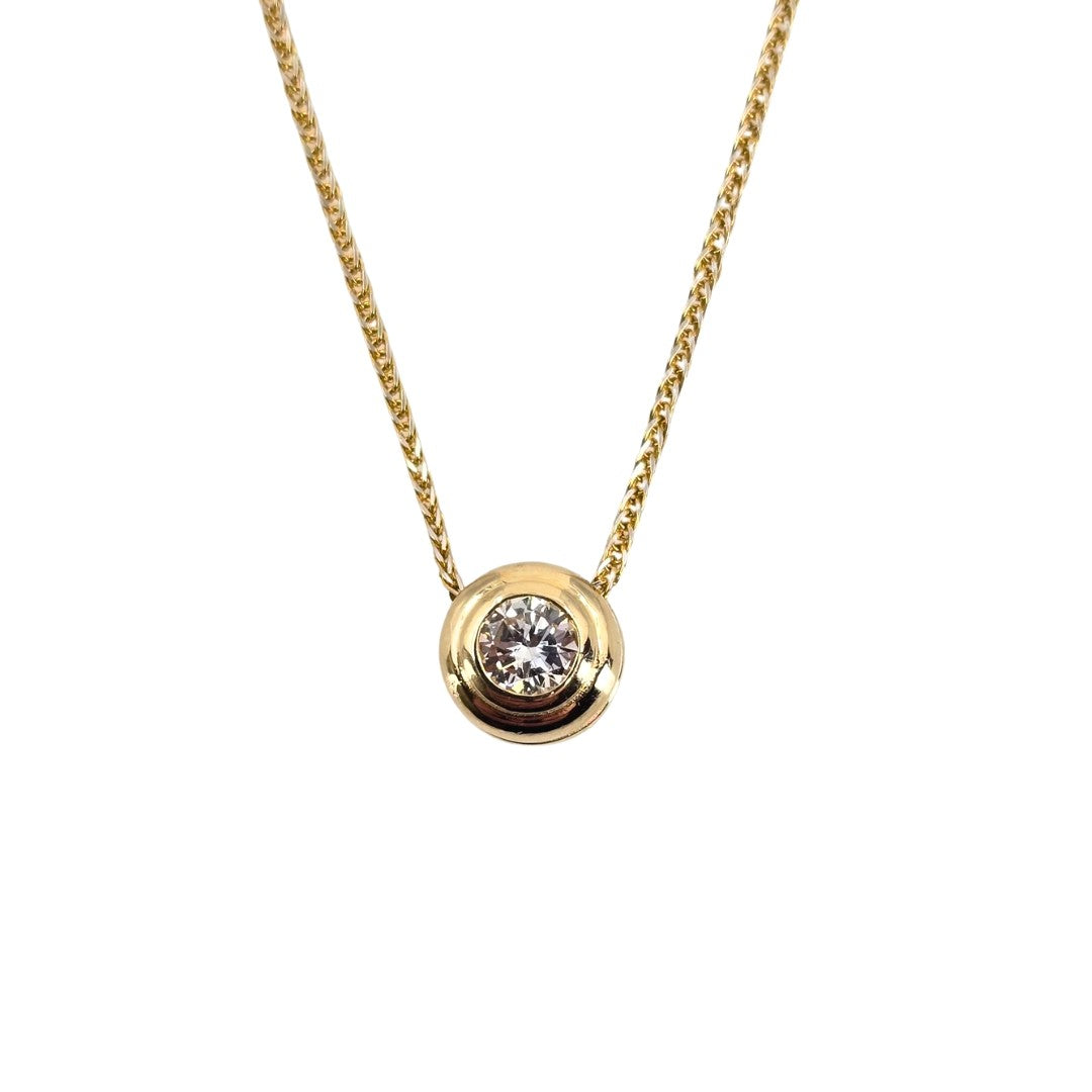 Yellow gold necklace with a central sparkling diamond stone in a yellow gold bezel setting.