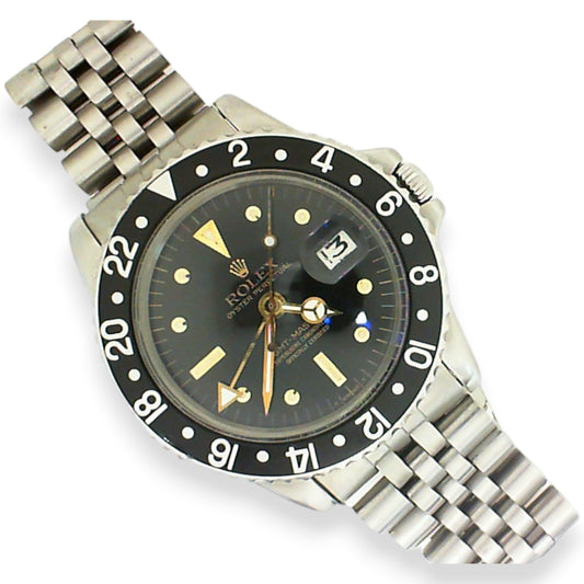 Vintage stainless steel Rolex GMT watch circa 1974 featuring a rare gold nipple dial, raised gold hour markers, and classic luxury sports watch styling.