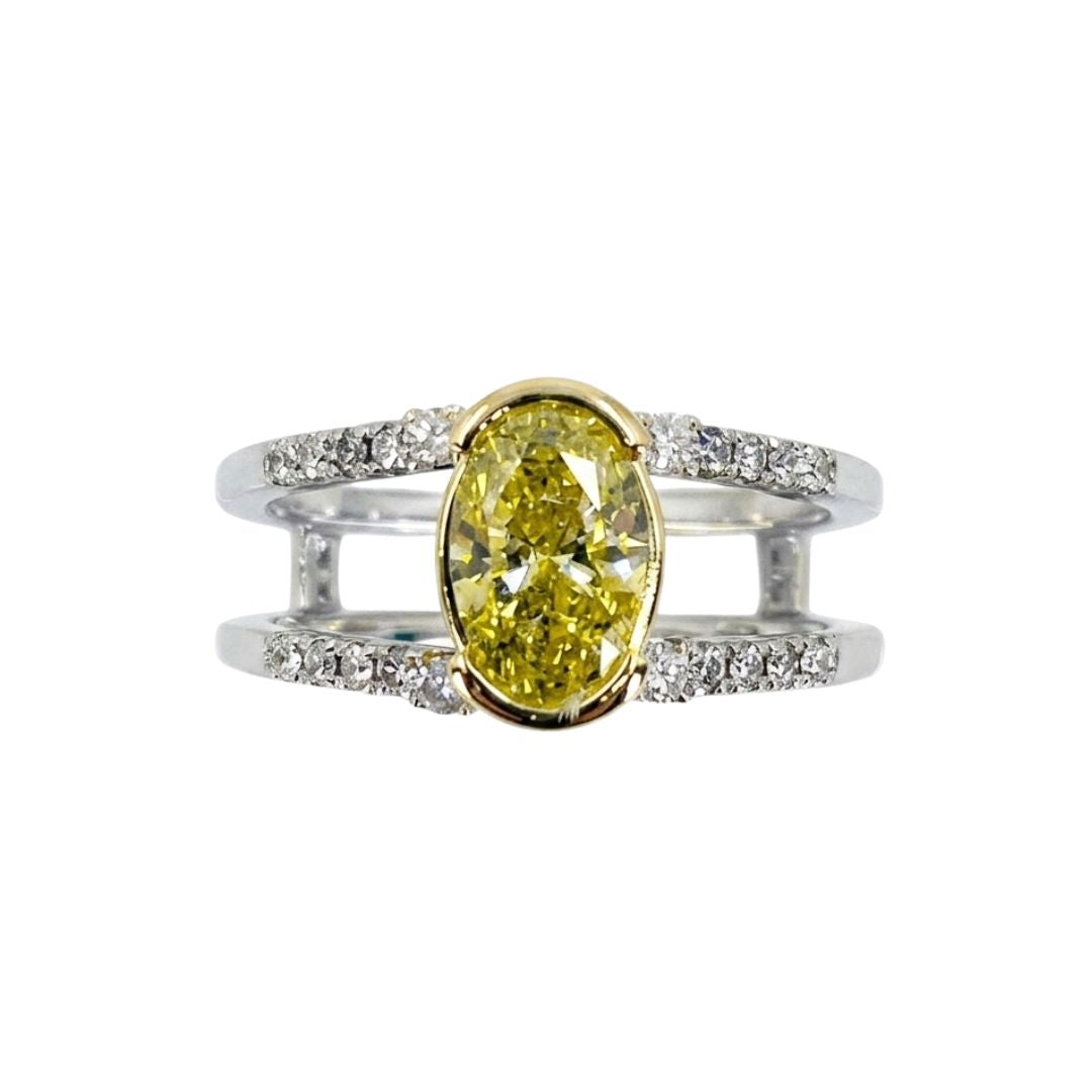 White gold split shank ring set with round diamonds and a vibrant oval yellow diamond centerpiece.