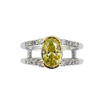White gold split shank ring set with round diamonds and a vibrant oval yellow diamond centerpiece.