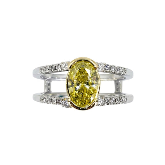 White gold split shank ring set with round diamonds and a vibrant oval yellow diamond centerpiece.